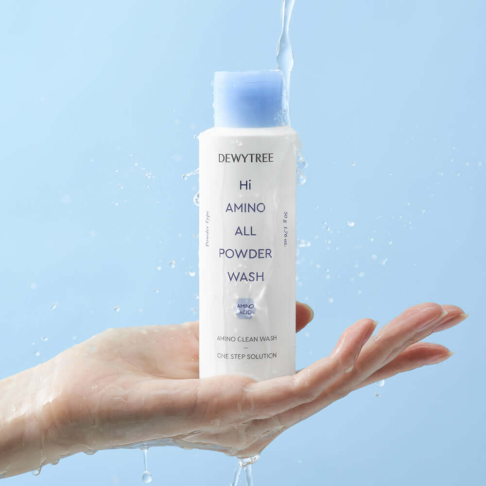 DEWYTREE Hi Amino All Enzyme Powder Wash 50g in hand with water splashing on the bottle, clean skincare product display.