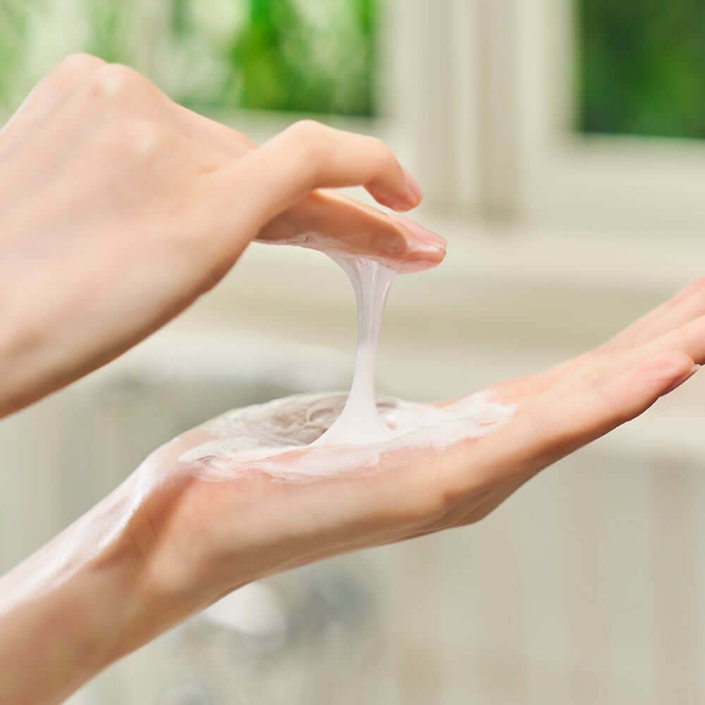 Applying DEWYTREE Hi Amino All Enzyme Powder Wash 50g on hand with creamy texture focus