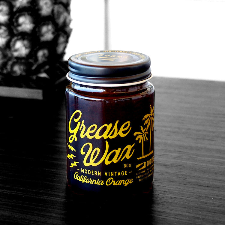 DOORS California Beach Orange Grease Wax 80g jar on dark wood table, Gentleman Korea men’s hair styling product for modern vintage look