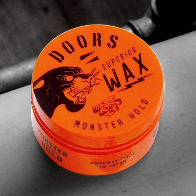 DOORS Superior Wax Monster Hold 80g on gray surface, bright orange tin packaging for men’s styling by Gentleman Korea