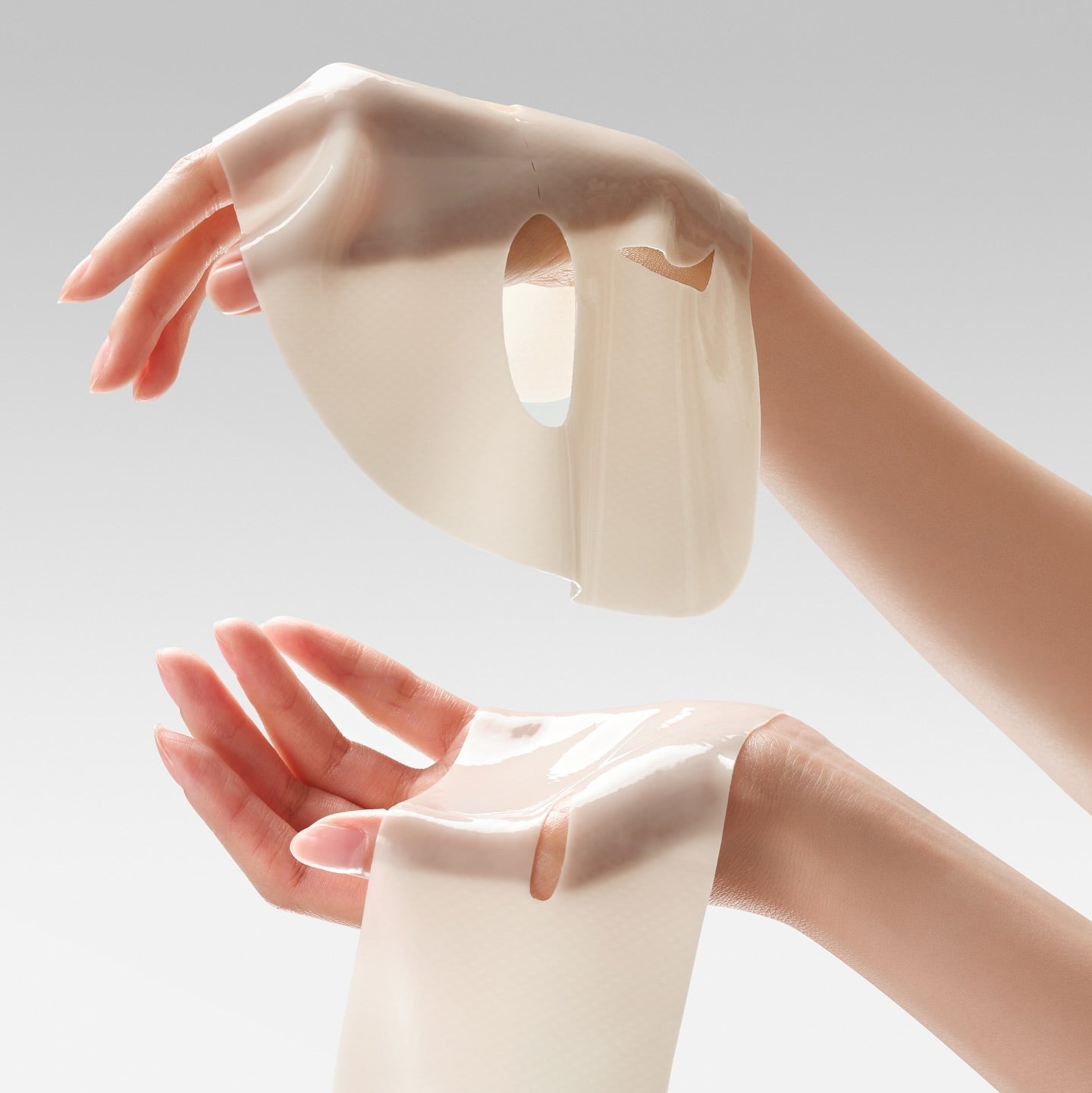 DR.CEURACLE Vegan Kombucha Tea Essence-in-Gel Mask being held between two hands, showcasing its texture and gel-like appearance.