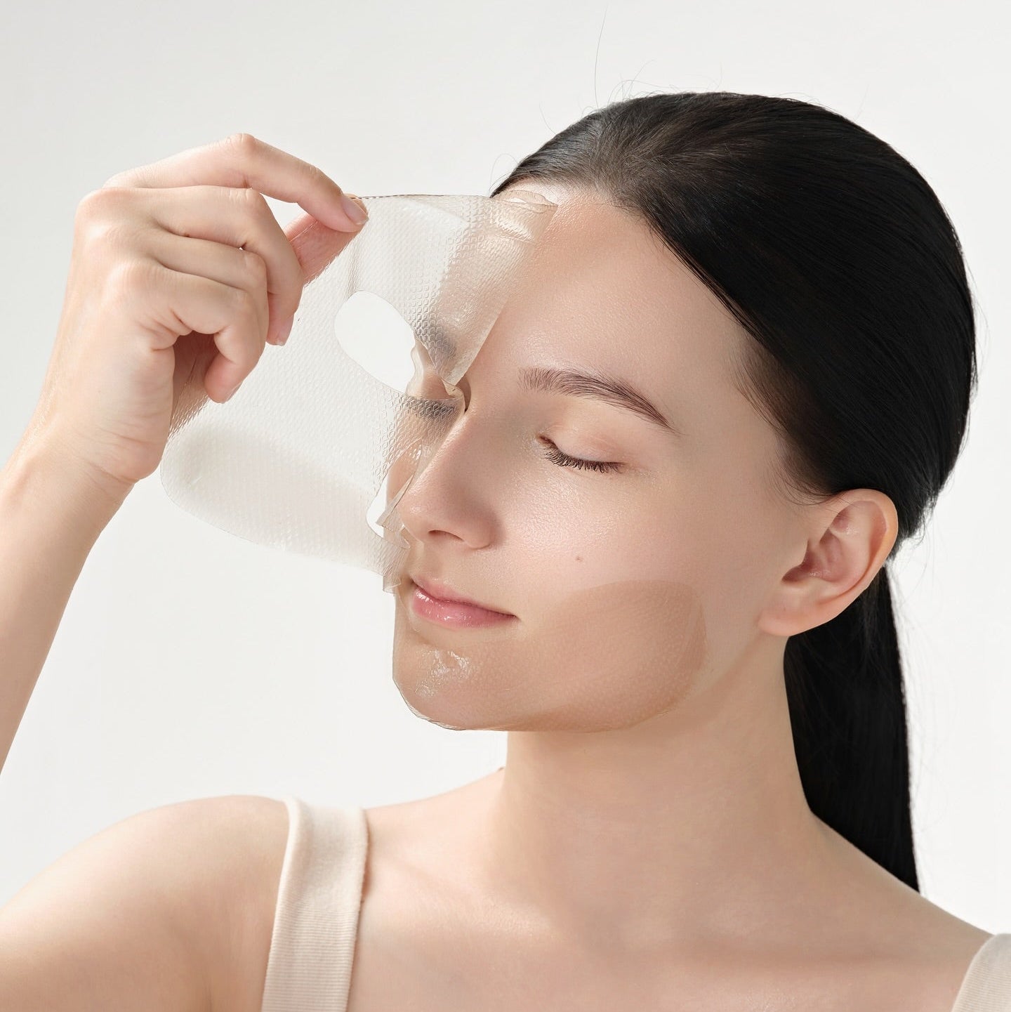Woman applying DR.CEURACLE Vegan Kombucha Tea Essence-in-Gel Mask for skincare