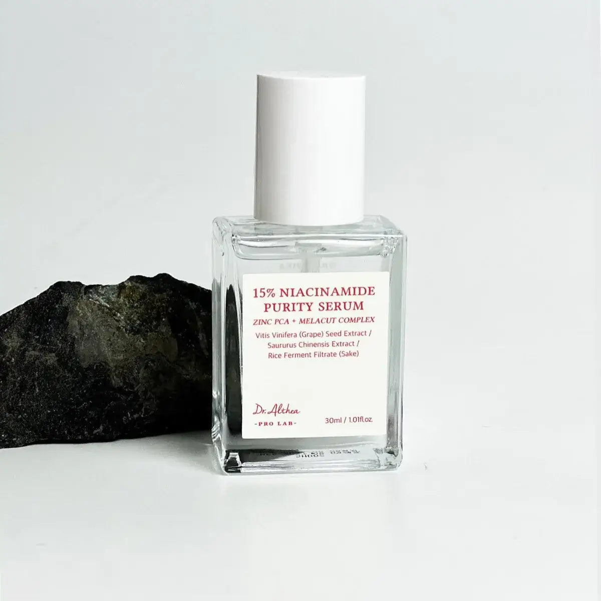 DR.ALTHEA 15% Niacinamide Purity Serum 30ml bottle with a rock background