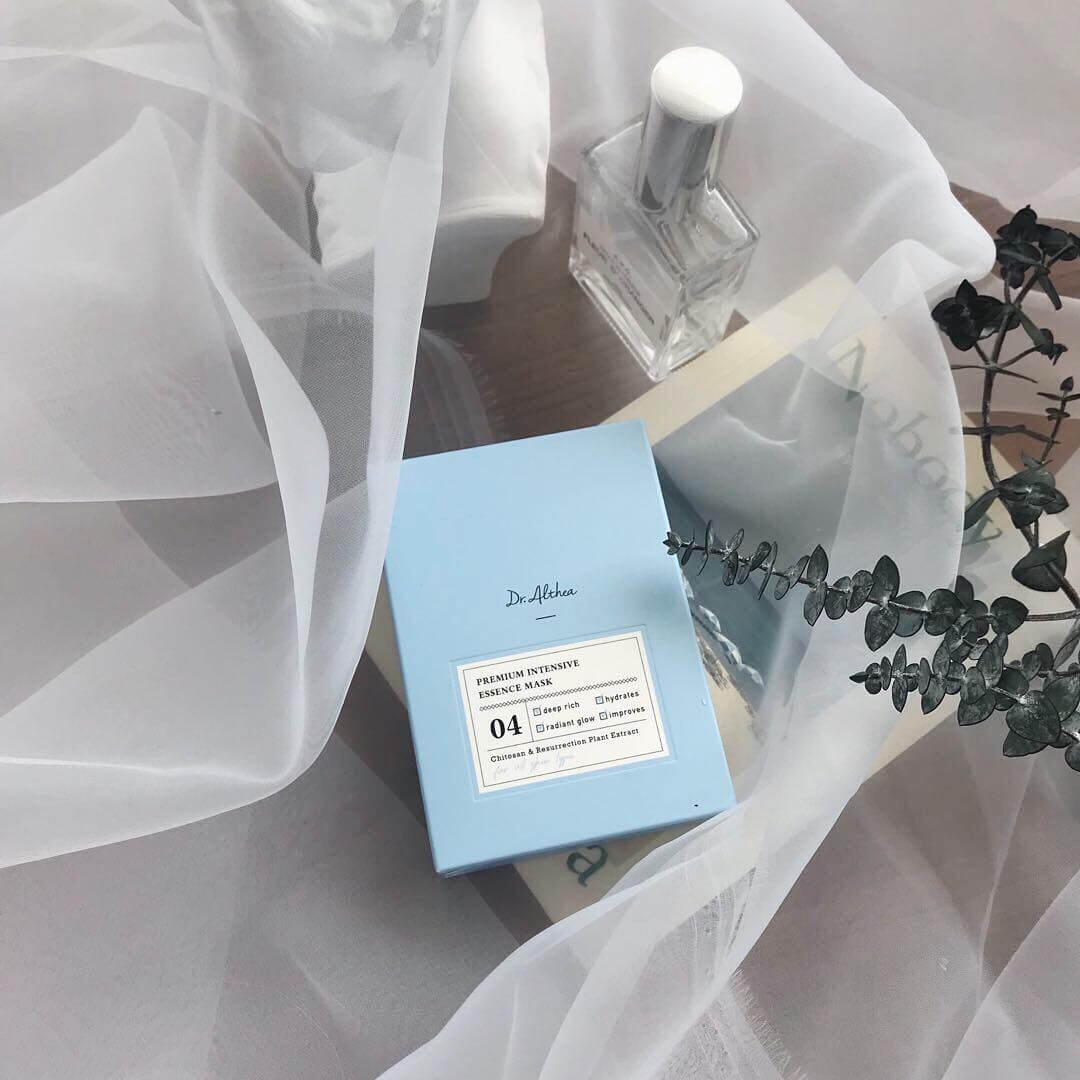 DR.ALTHEA Premium Intensive Essence Mask box with elegant packaging surrounded by sheer fabric and eucalyptus leaves.