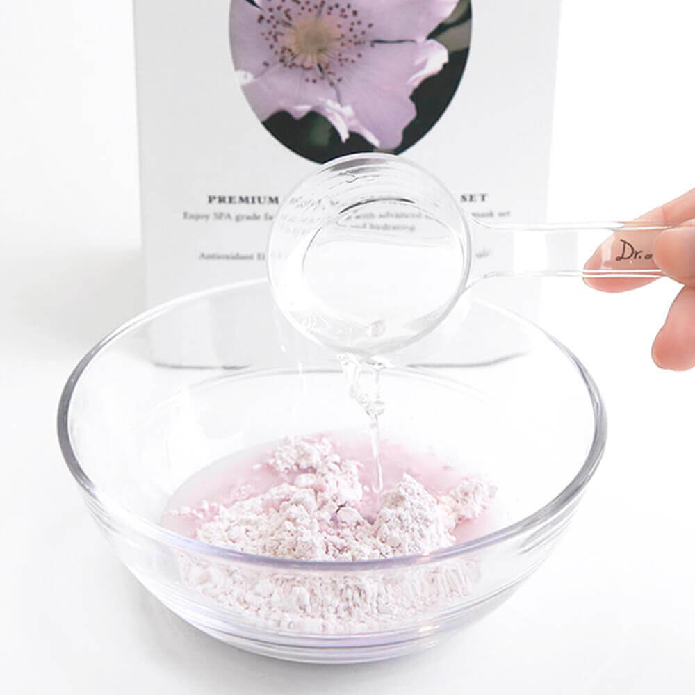 Mixing DR.ALTHEA Premium Rosa Modeling Mask Set (5ea) 25g with water in a clear bowl for skincare.
