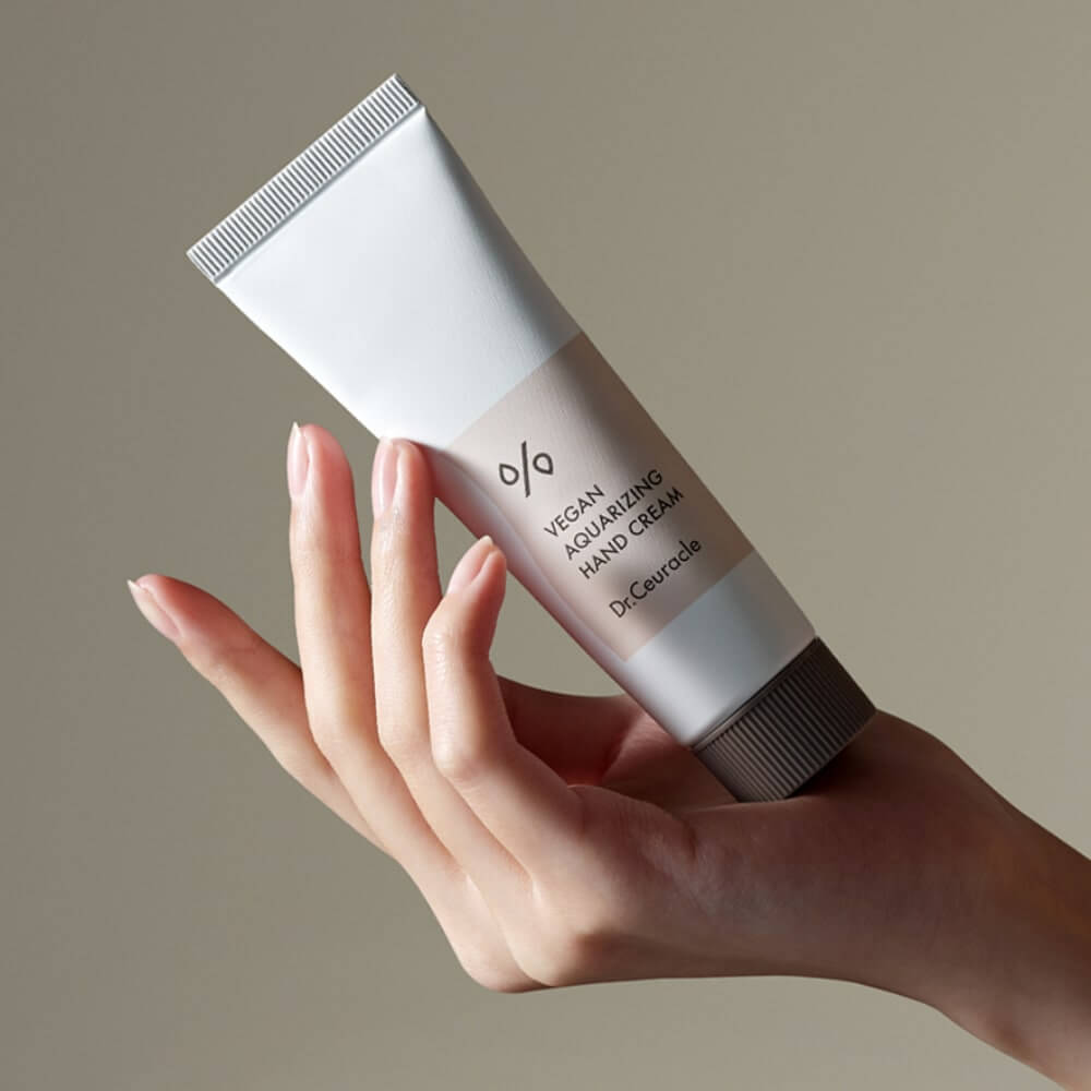 DR.CEURACLE Aqua Rising Hand cream 50ml held in hand, elegant tube design