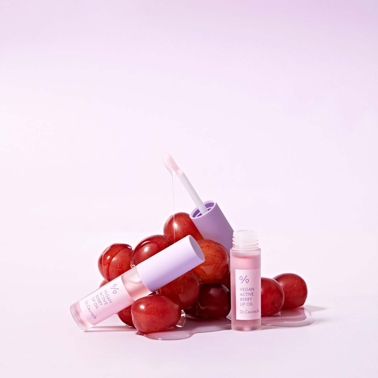 DR.CEURACLE Vegan Active Berry Lip Oil with grape background showcasing natural ingredients and hydrating formula.