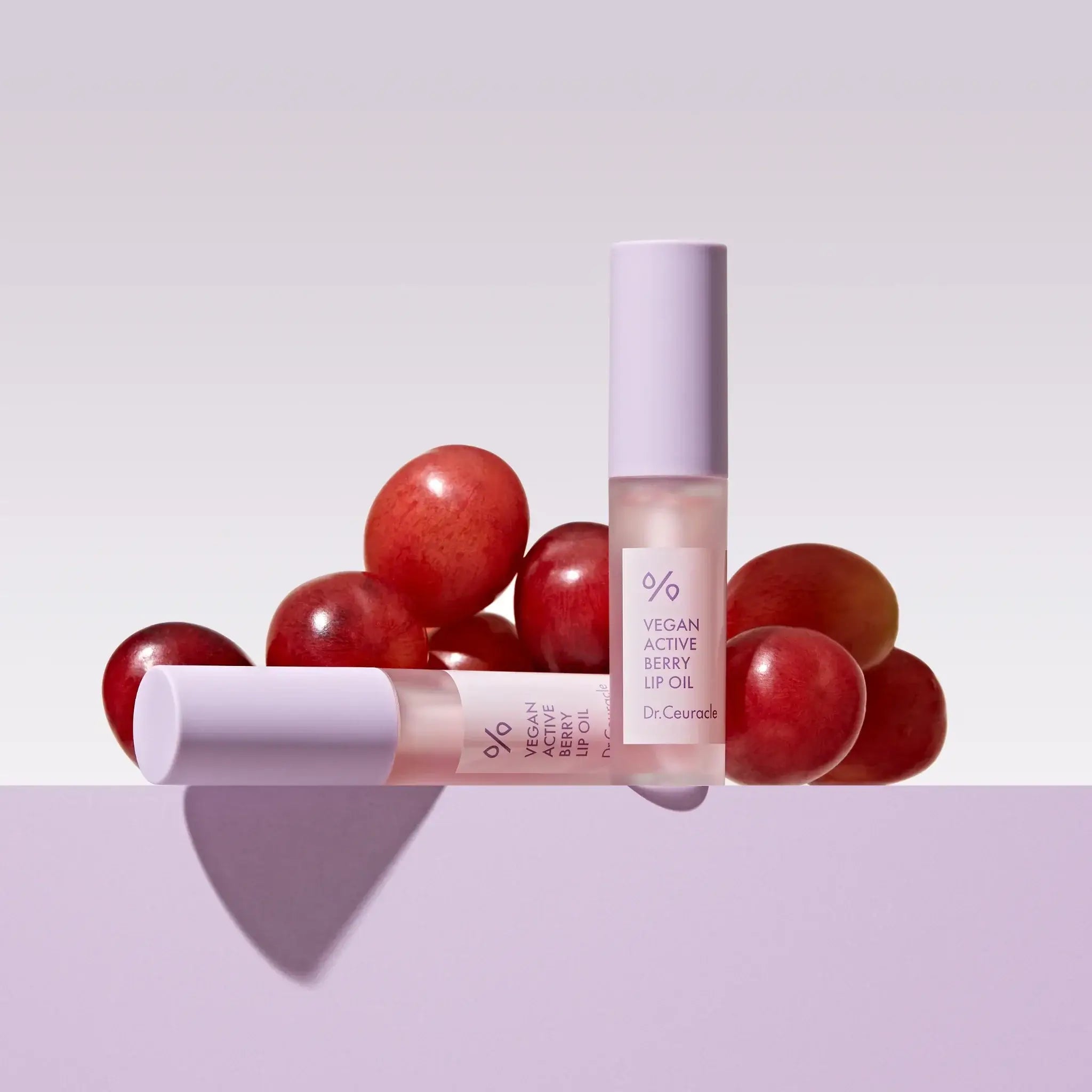 DR.CEURACLE Vegan Active Berry Lip Oil with grape background, nourishing lip care product displayed elegantly.