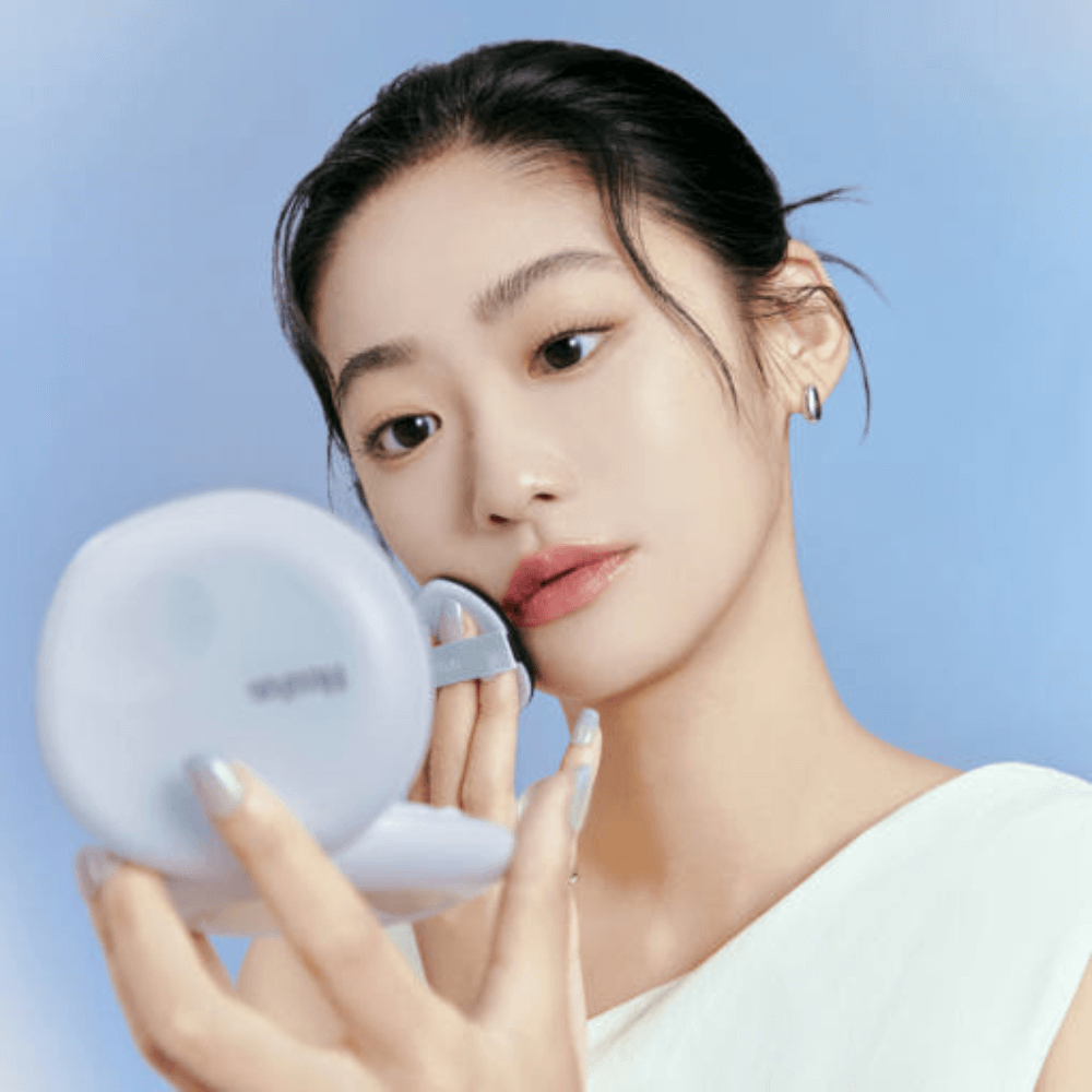 Woman applying DR.G Breath Cushion Cloud SPF50 PA+++ with compact mirror in hand.