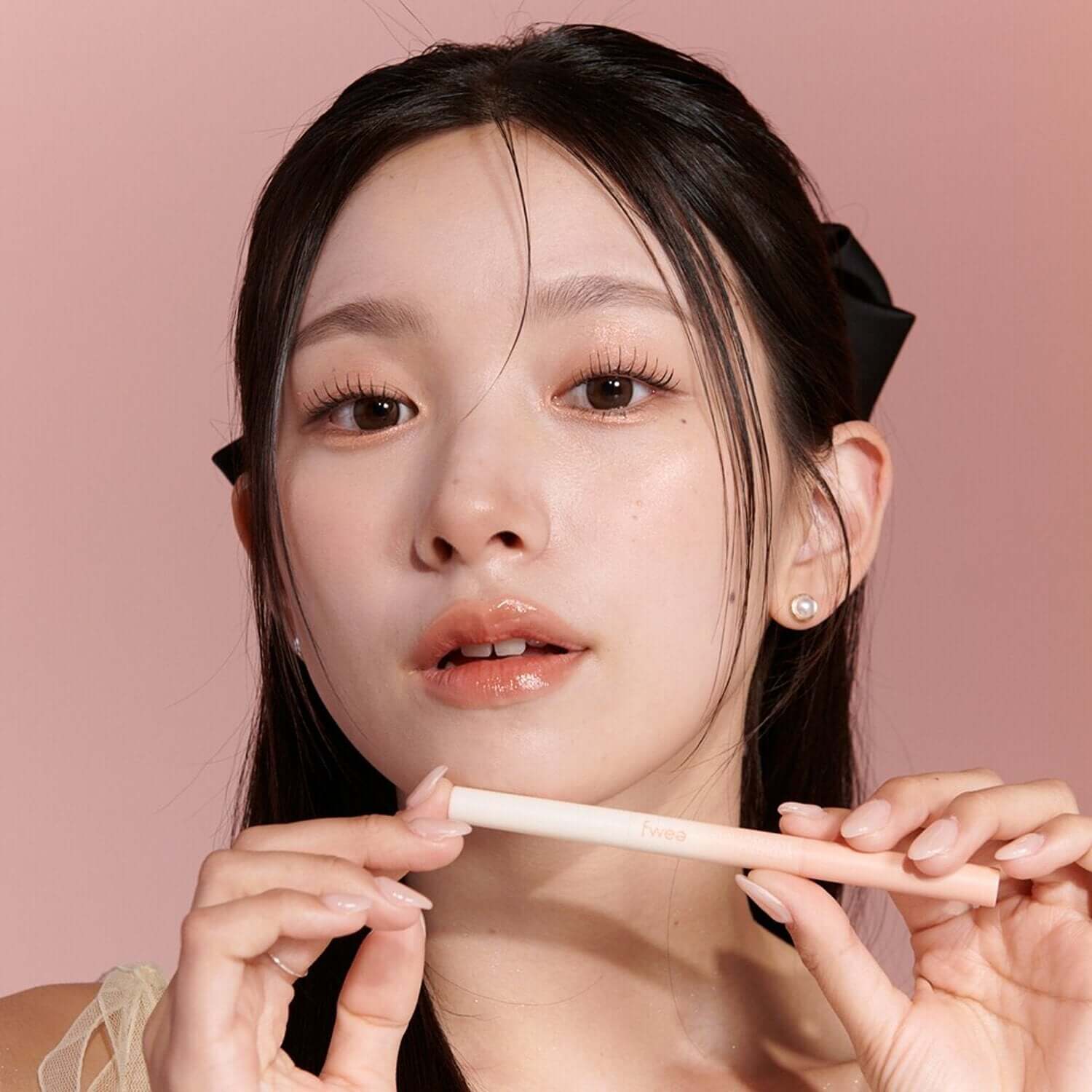 Woman holding FWEE Dual Aego Sal Full-Filler with elegant presentation against pink background