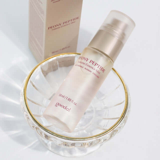 GOODAL Peony Peptide Wrinkle Volume Essence Mist 50ml bottle displayed on a clear glass dish.
