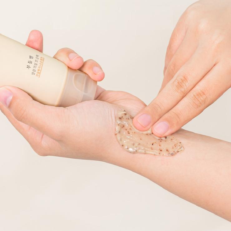 Applying HANYUL Buddle Night Clean Exfoliating Pore Pack on skin from a tube.