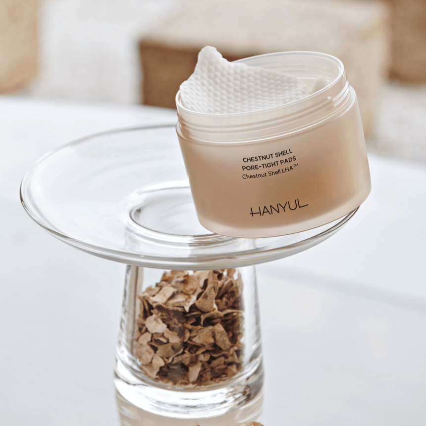 HANYUL Buddleberry Pore Tightening Pad on glass stand next to dried herbs, showcasing pore care and tightening benefits.