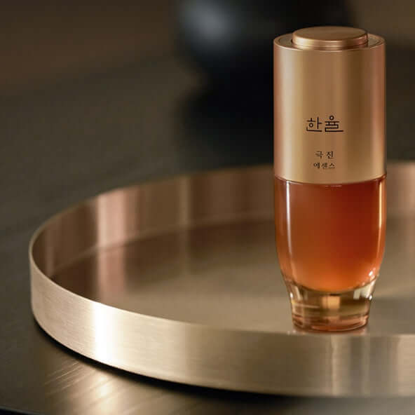 HANYUL Extreme Essence Planning Set product bottle on a metallic tray showcasing elegant packaging and design.