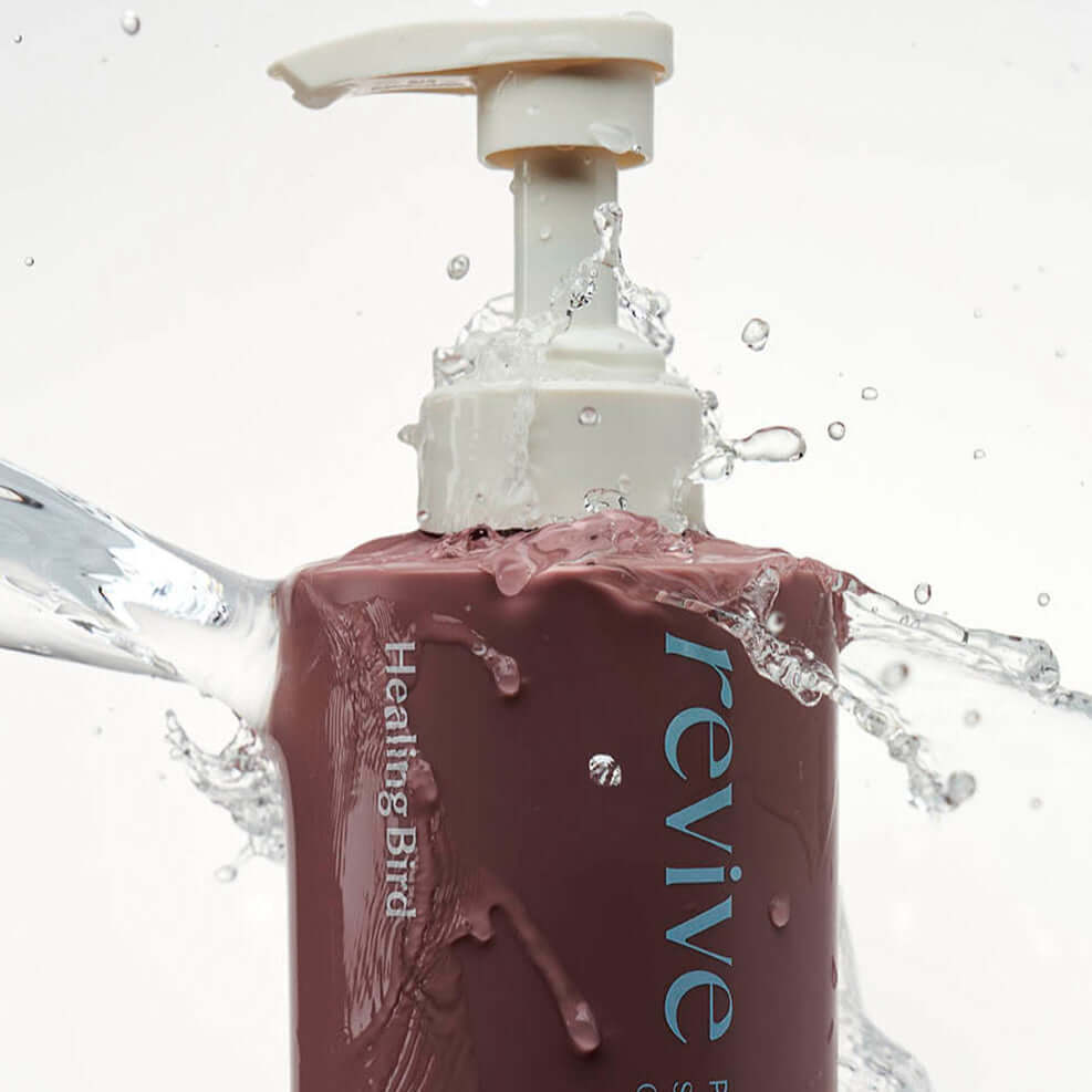 HEALING BIRD Revive Protein Shampoo 500ml bottle with water splash highlighting its hydrating properties