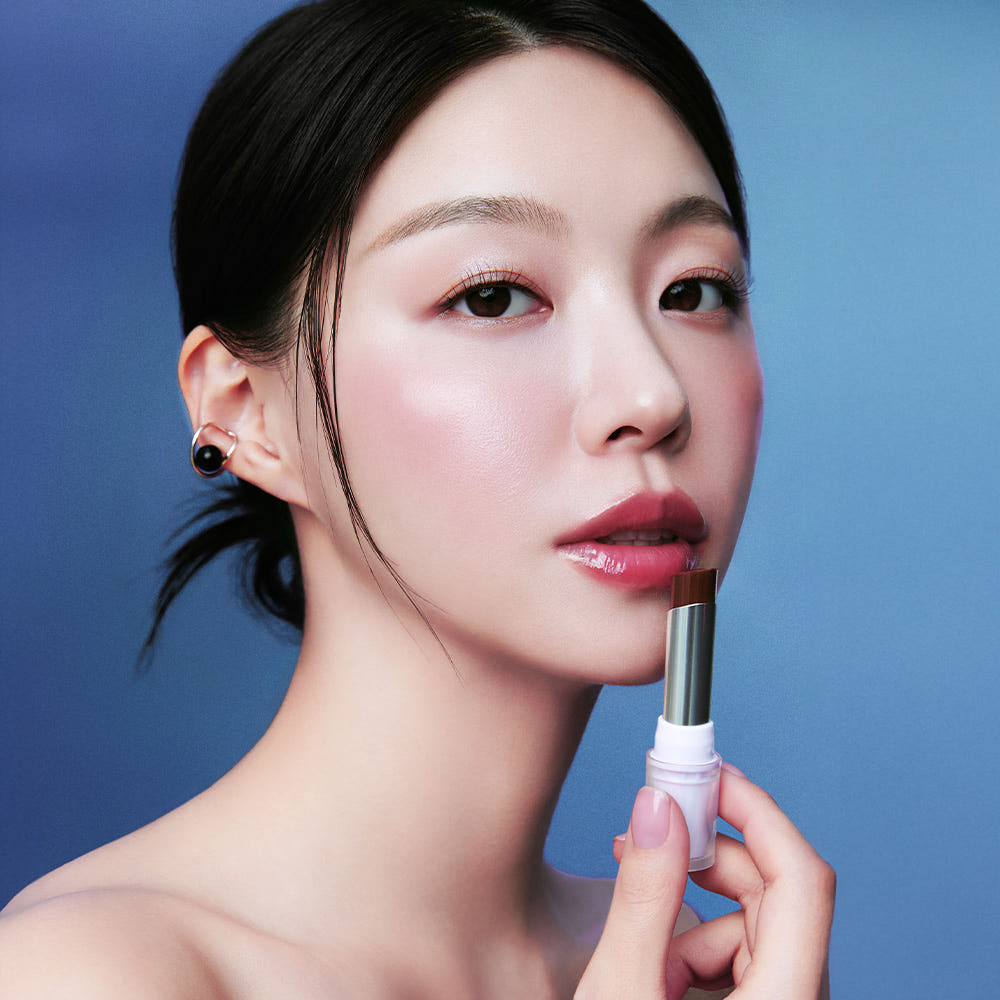 Woman applying HEALUS Bare Lip Glow 4g for a natural look