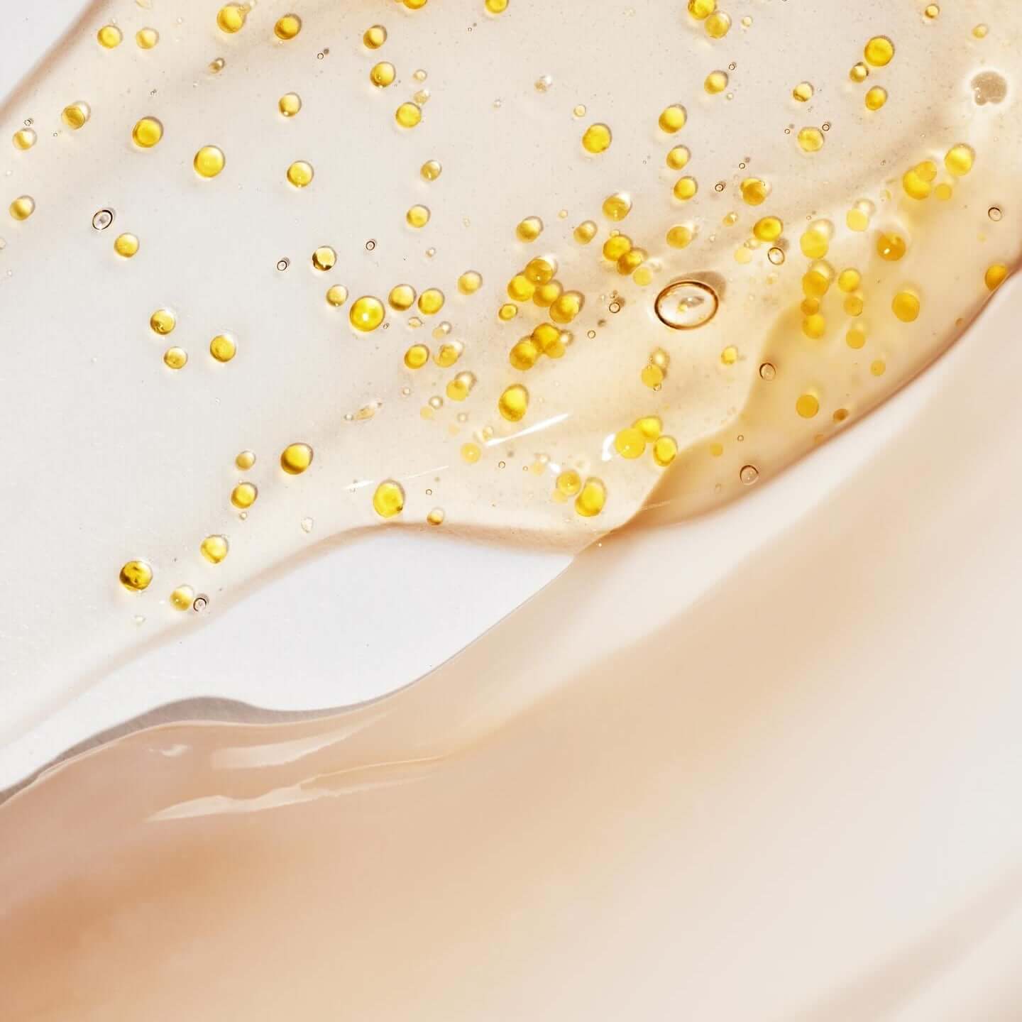 HUXLEY Biosys 360 Ampoule texture with golden droplets on a light background