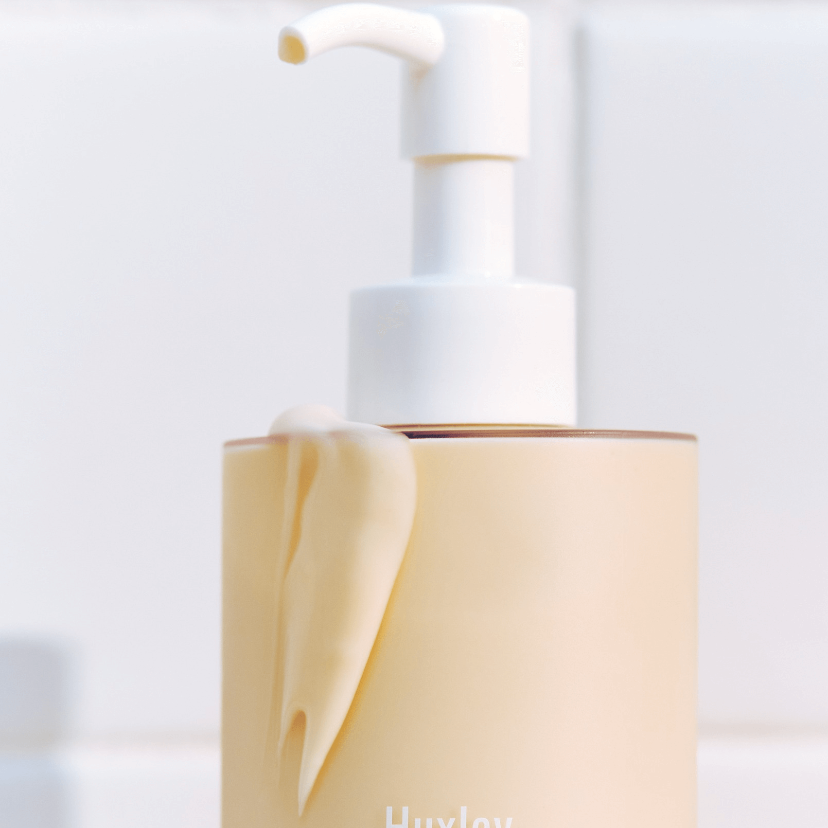 Bottle of HUXLEY Body Lotion Blue Madina Tangerine with pump on a white background.