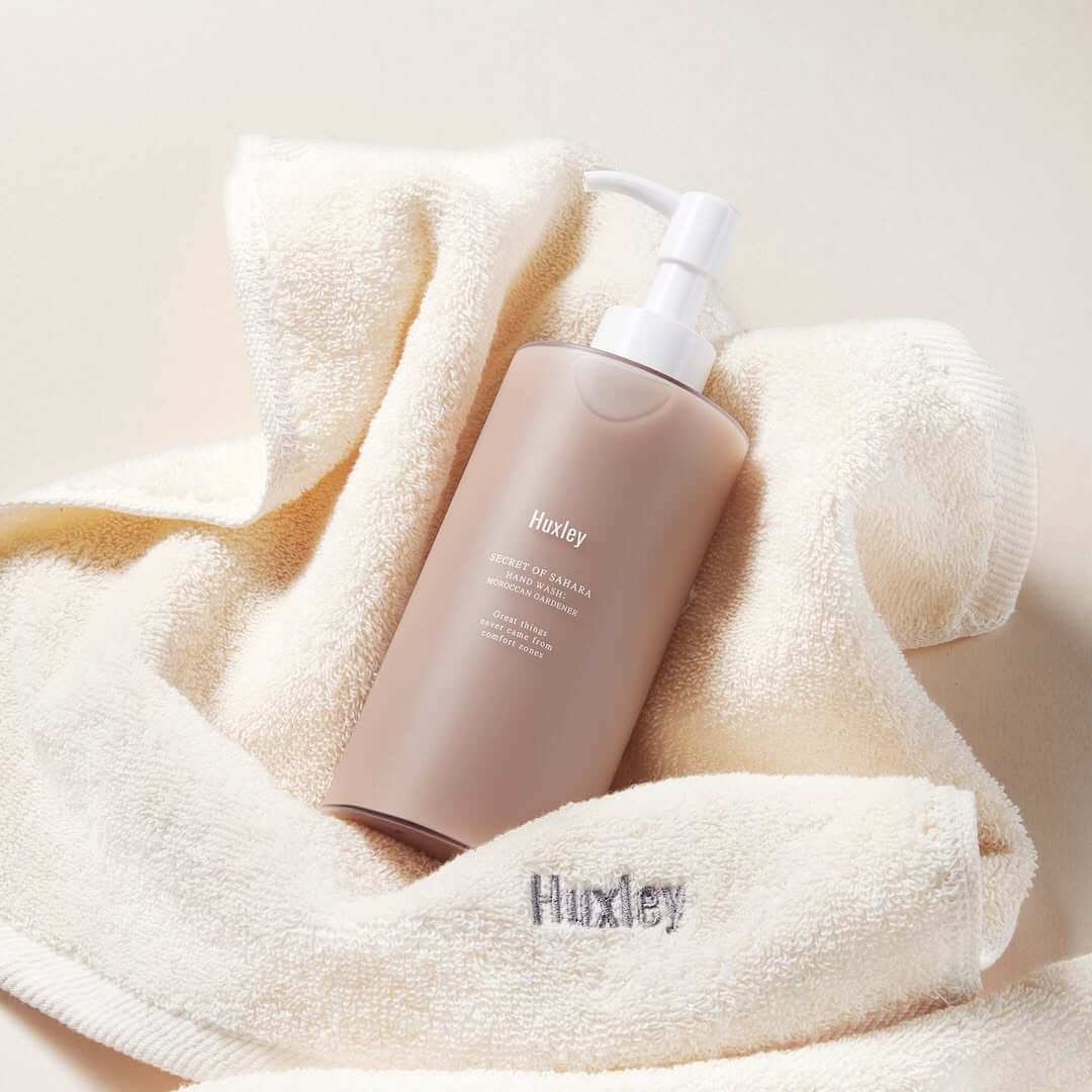HUXLEY Hand Wash Moroccan Gardener bottle on a soft towel, showcasing luxurious hand cleansing solution with a touch of elegance