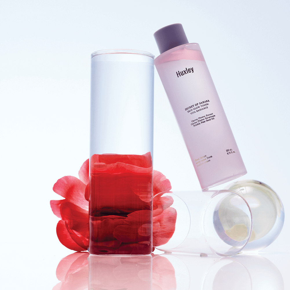 HUXLEY Skin Glow Toner Vita Radiance bottle with clear liquid and petals, promoting radiant skin.