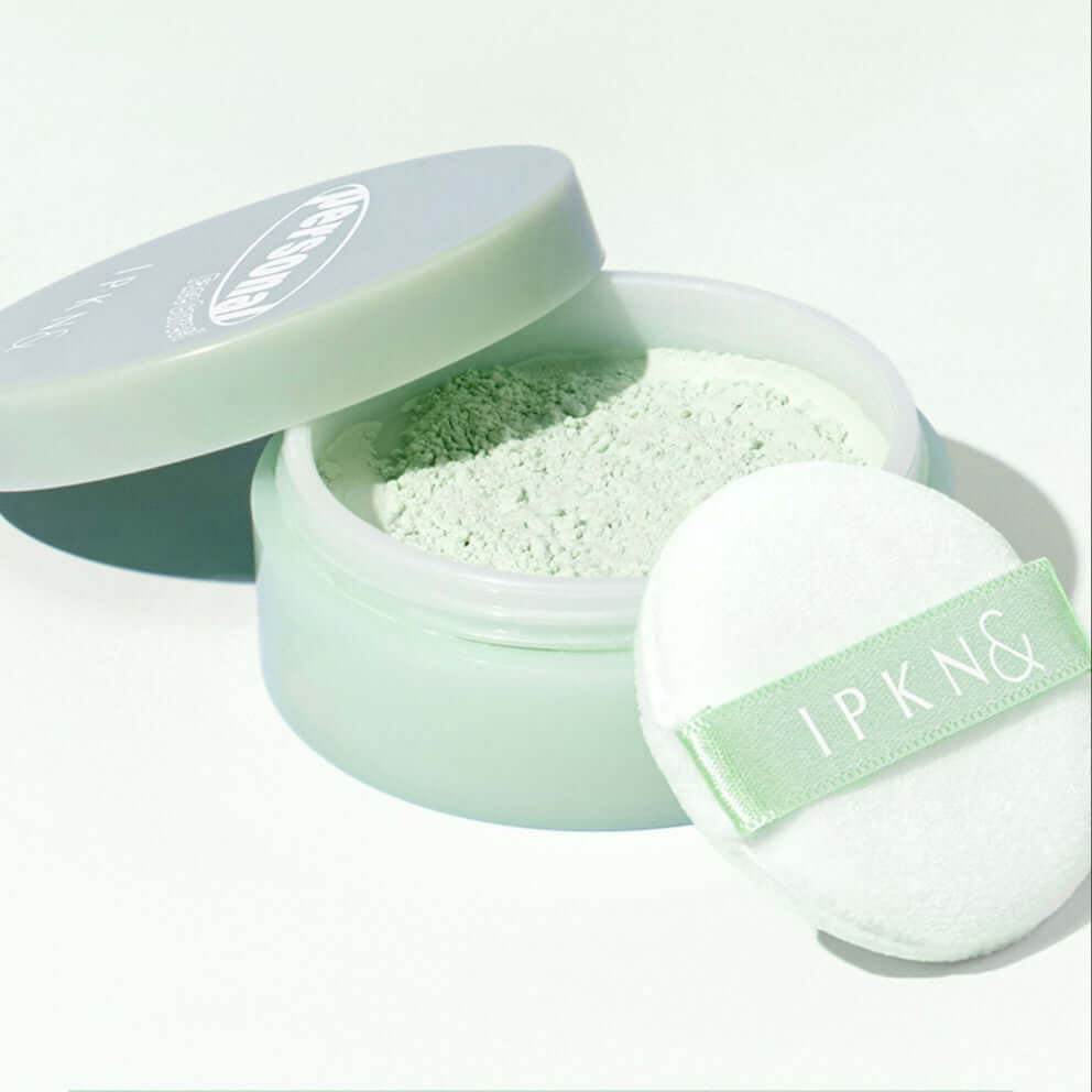 IPKN Personal Tone Correcting Powder (Green) with applicator in an open container, showcasing smooth texture and green color.
