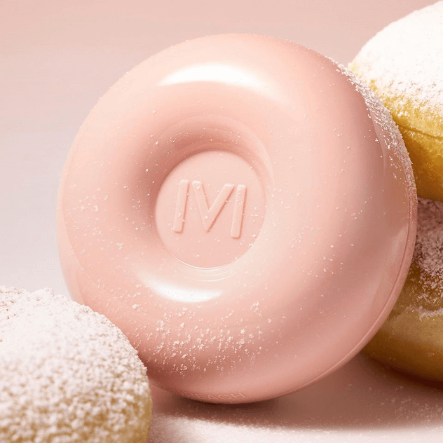 IVI MAD PEACH Sugar Powder Tone-Up Cushion surrounded by powdered donuts, showcasing its peachy tone and smooth finish.