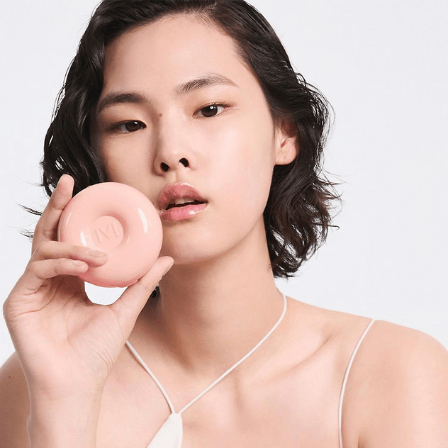 Model holding IVI MAD PEACH Sugar Powder Tone-Up Cushion, showcasing the product design and packaging.