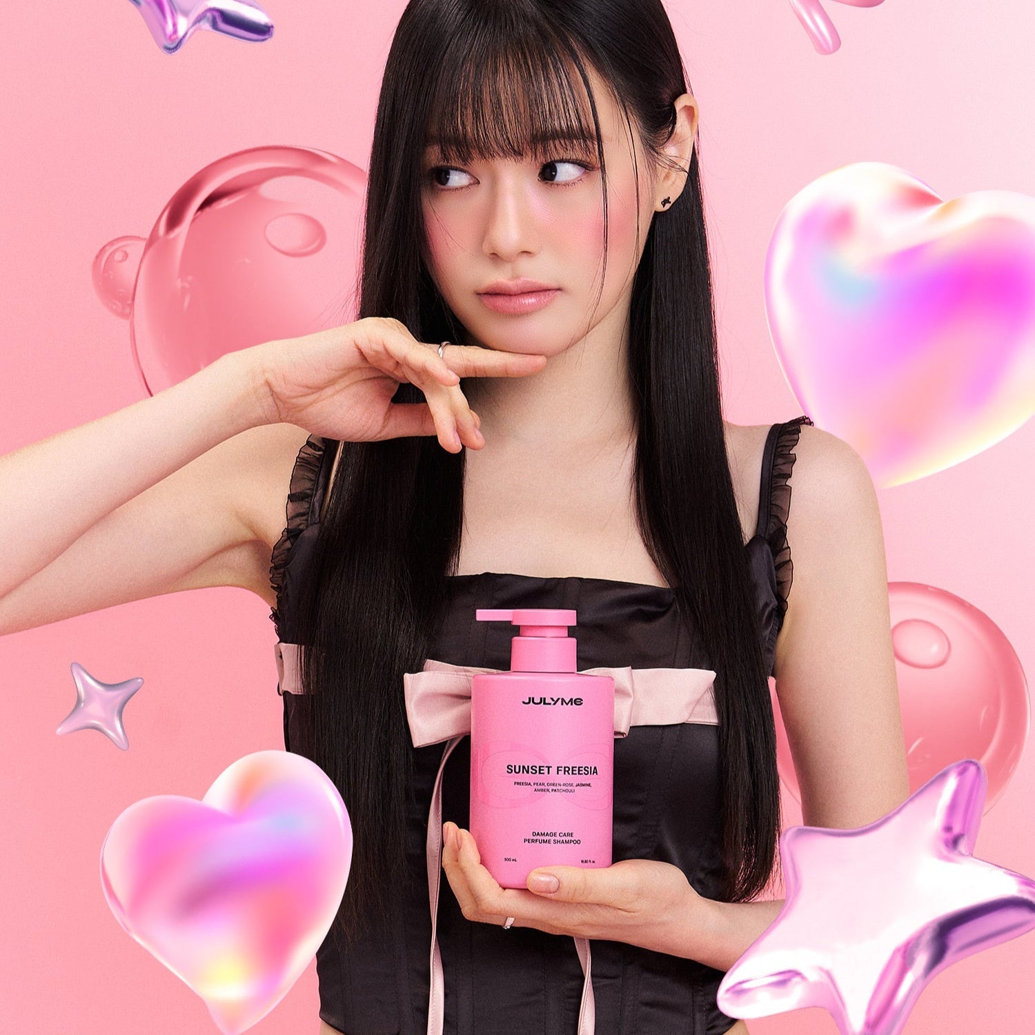 JULYME Damage Care Collagen Shampoo 500ml (Sunset Freesia) being held by model, with lively pink and heart elements in the background.