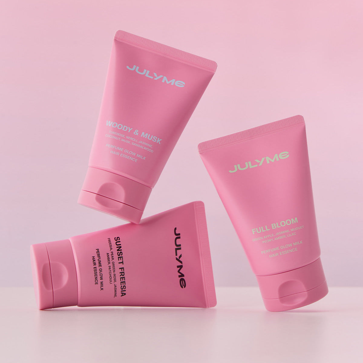 JULYME Perfume Glow Milk Hair Essence 80ml ( Full Bloom) - three pink tubes on a light pink background showcasing the hair essence product line.