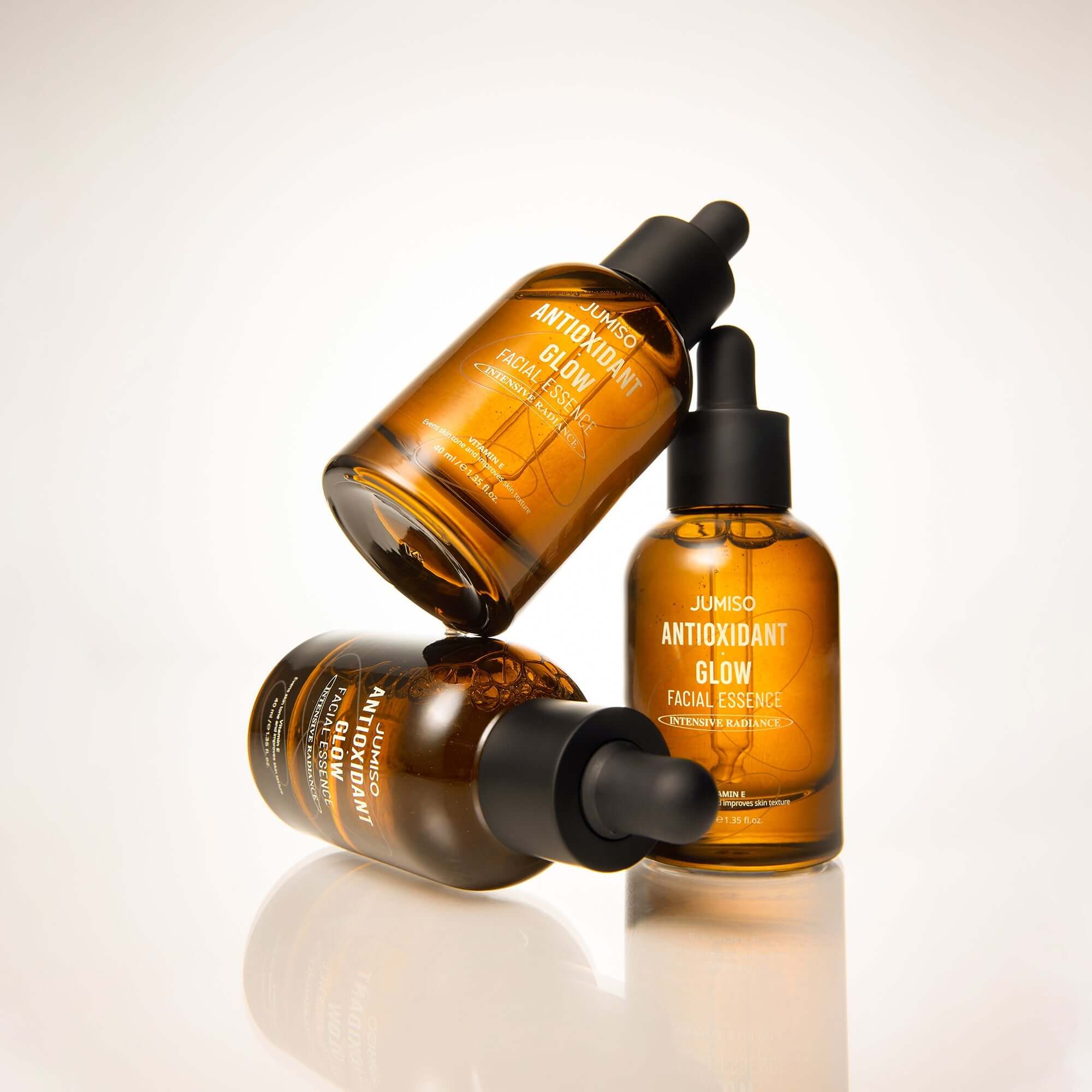JUMISO Antioxidant Glow Facial Essence bottles showcasing radiant skincare essence in amber glass packaging.