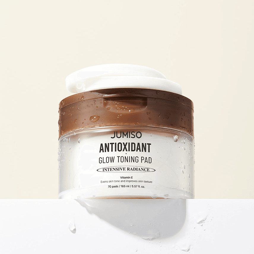 JUMISO Antioxidant Glow Toning Pads 70 Sheets container with wet surface showing packaging and branding.