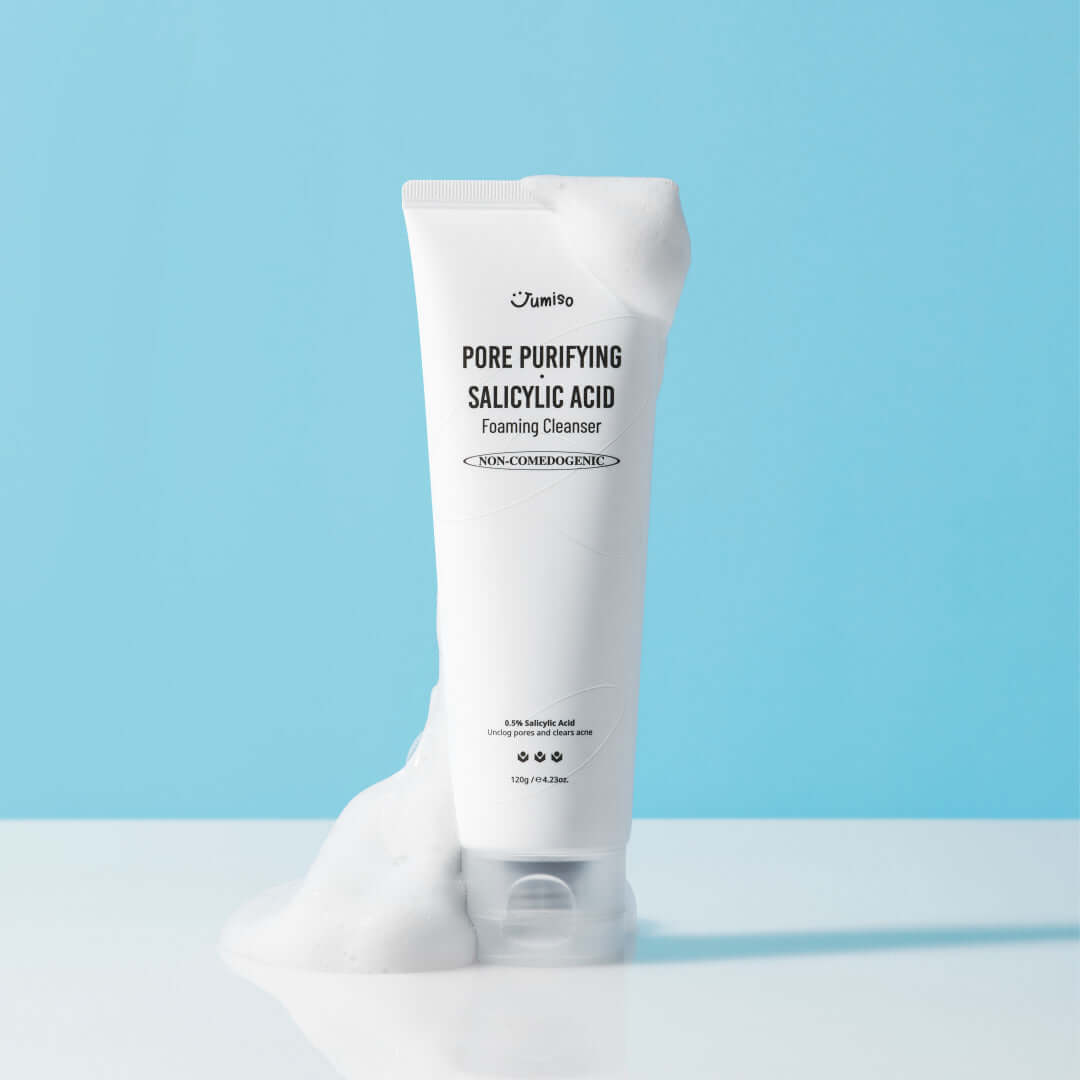 JUMISO Pore Purifiying Salicylic Acid Foaming Cleanser with foamy texture on light blue background.