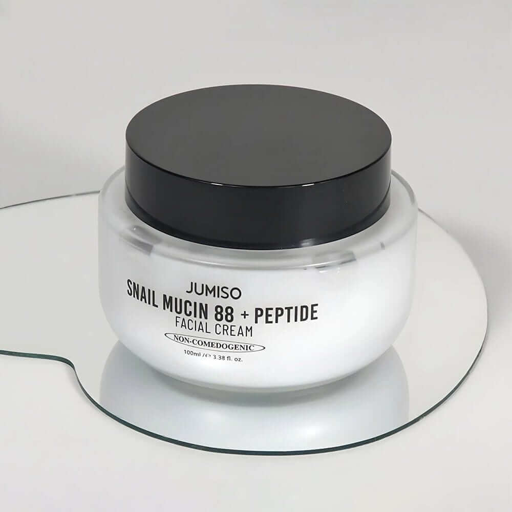 JUMISO Snail Muci 88 + Peptide Cream jar on mirror surface