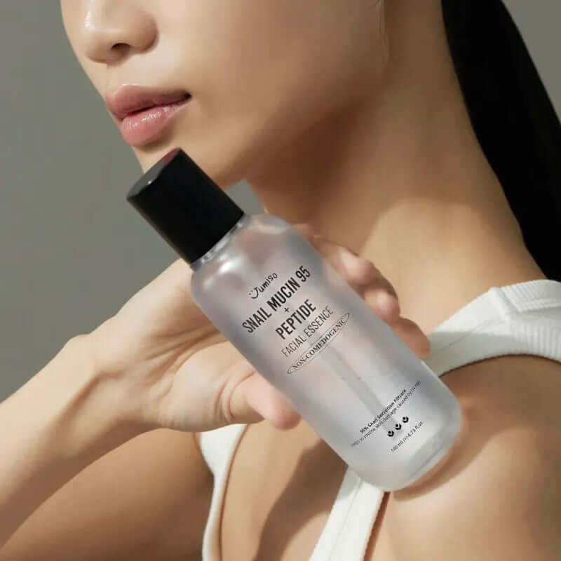 Woman holding JUMISO Snail Mucin 95+ Peptide Facial Essence 140ml bottle