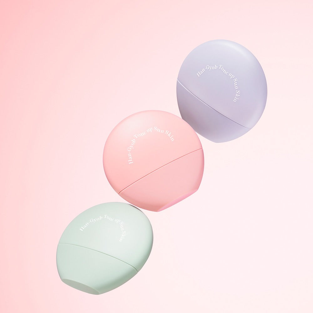 KAHI One Layer Tone-up Sun Skin 40ml bottles in pastel colors on a pink background