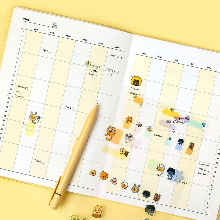 Open KAKAO FRIENDS Monthly Planner A5 with yellow pen and character stickers on monthly view pages.