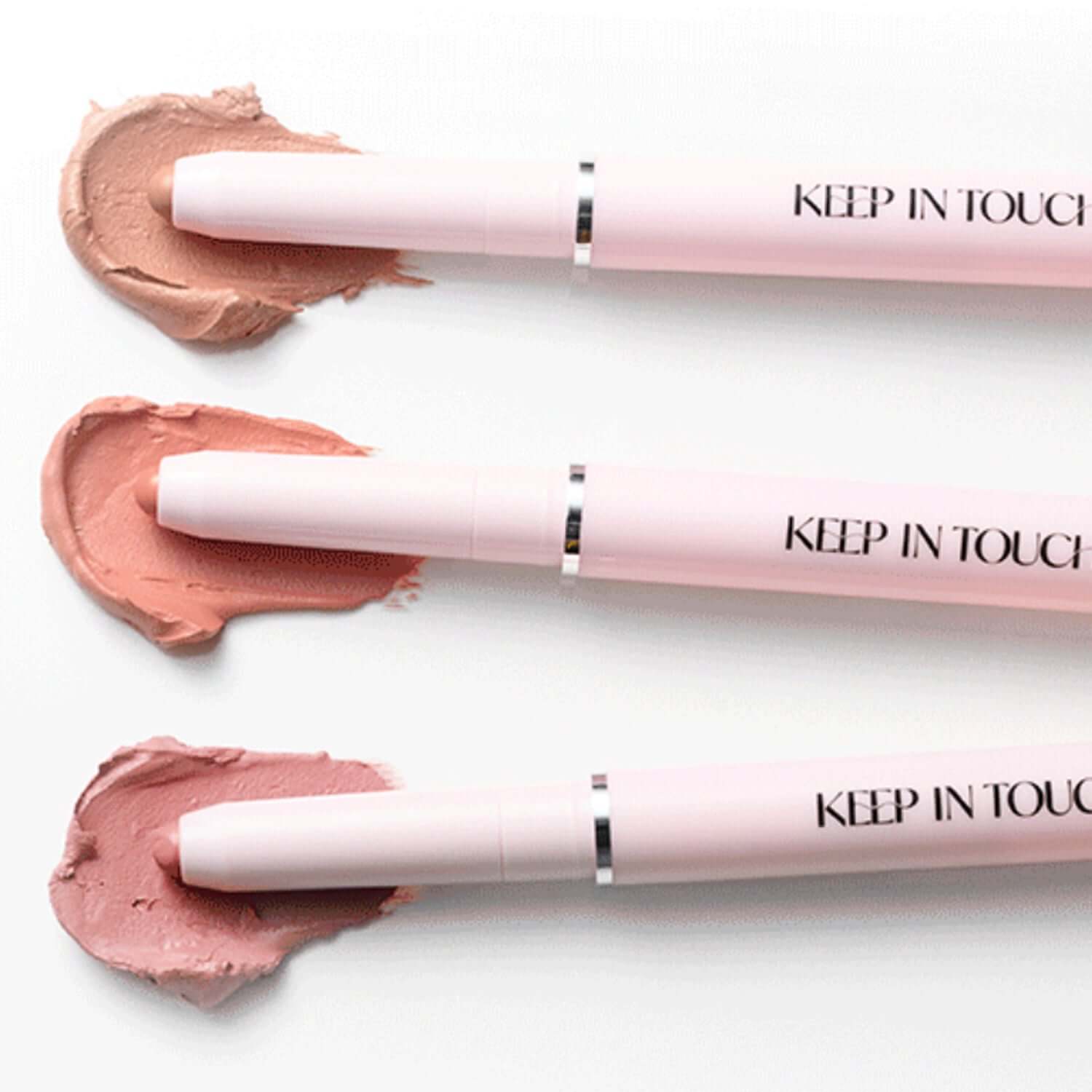 Three KEEP IN TOUCH Glow Lip Sealer Pencils in various shades on white background, showcasing product design and color variety.