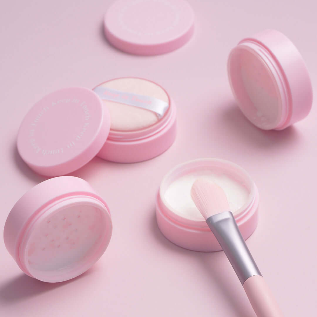 KEEP IN TOUCH Mini Pore Eraser Powder in pink containers with applicator brush, perfect for minimizing pores and evening skin tone.