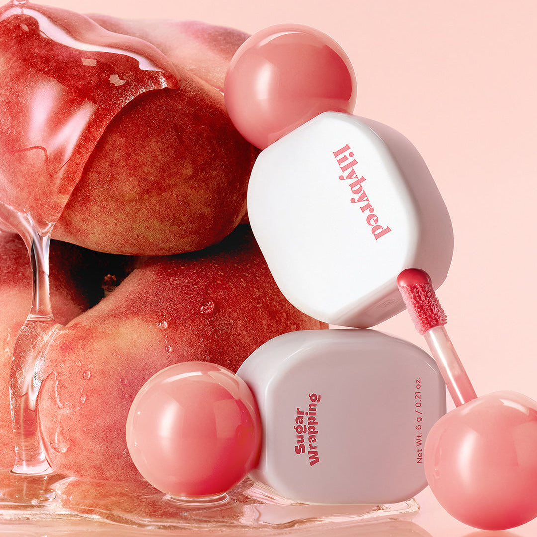LILIBYRED Sugar Wrapping Tint Gloss with peach backdrop showcasing lip gloss texture and luxury packaging.