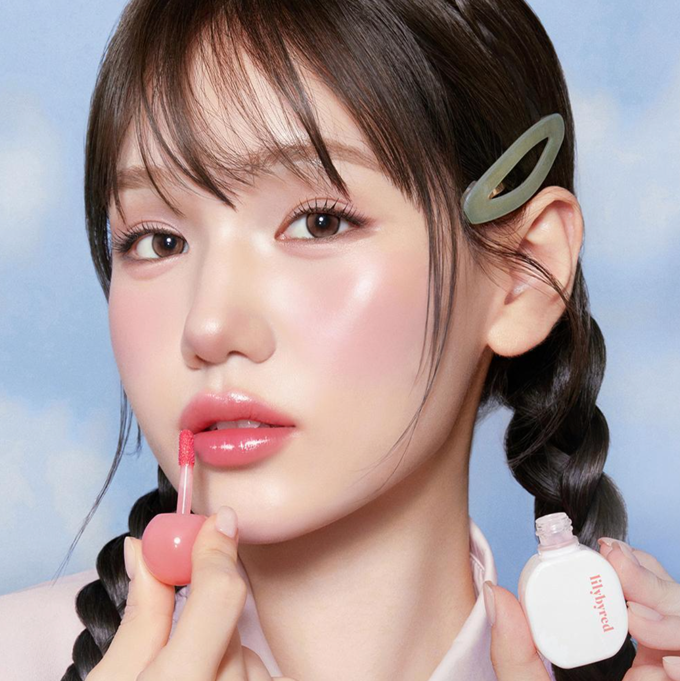 Model applying LILIBYRED Sugar Wrapping Tint Gloss for a glossy lip finish.