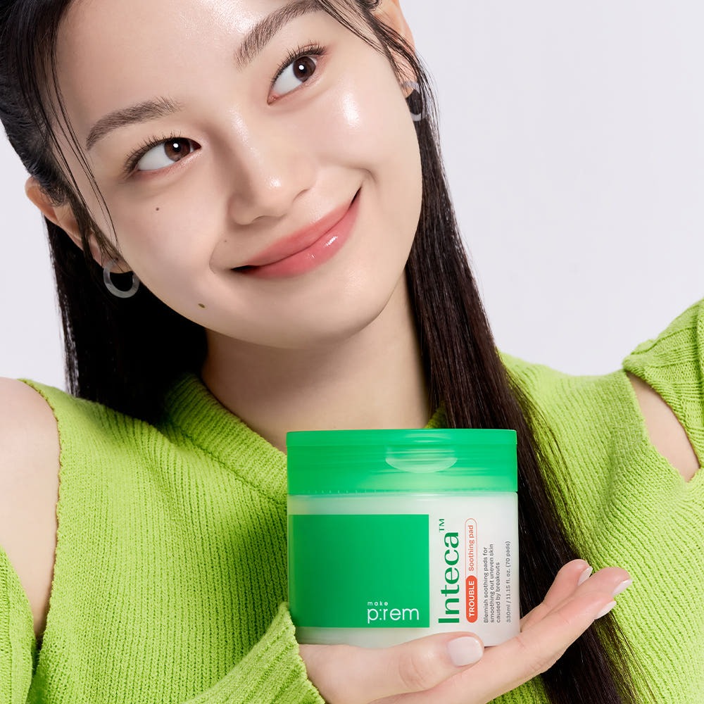 Woman holding MAKE P:REM Inteca Trouble Soothing Pads 70 sheets in a green container