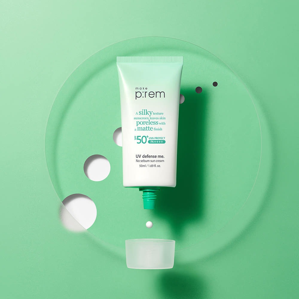 MAKE P:REM UV Defense Me No-Sebum Sunscreen 50ml on a green background with an open cap