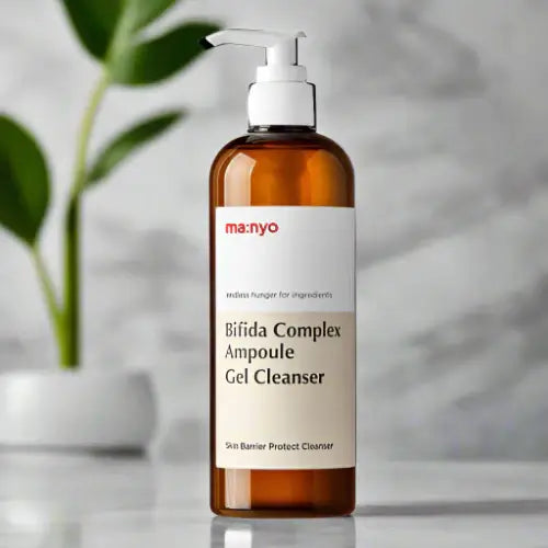 MANYO Bifida Complex Ampoule Gel Cleanser 400ml in amber bottle with pump, displayed on blurred background with plant decor.