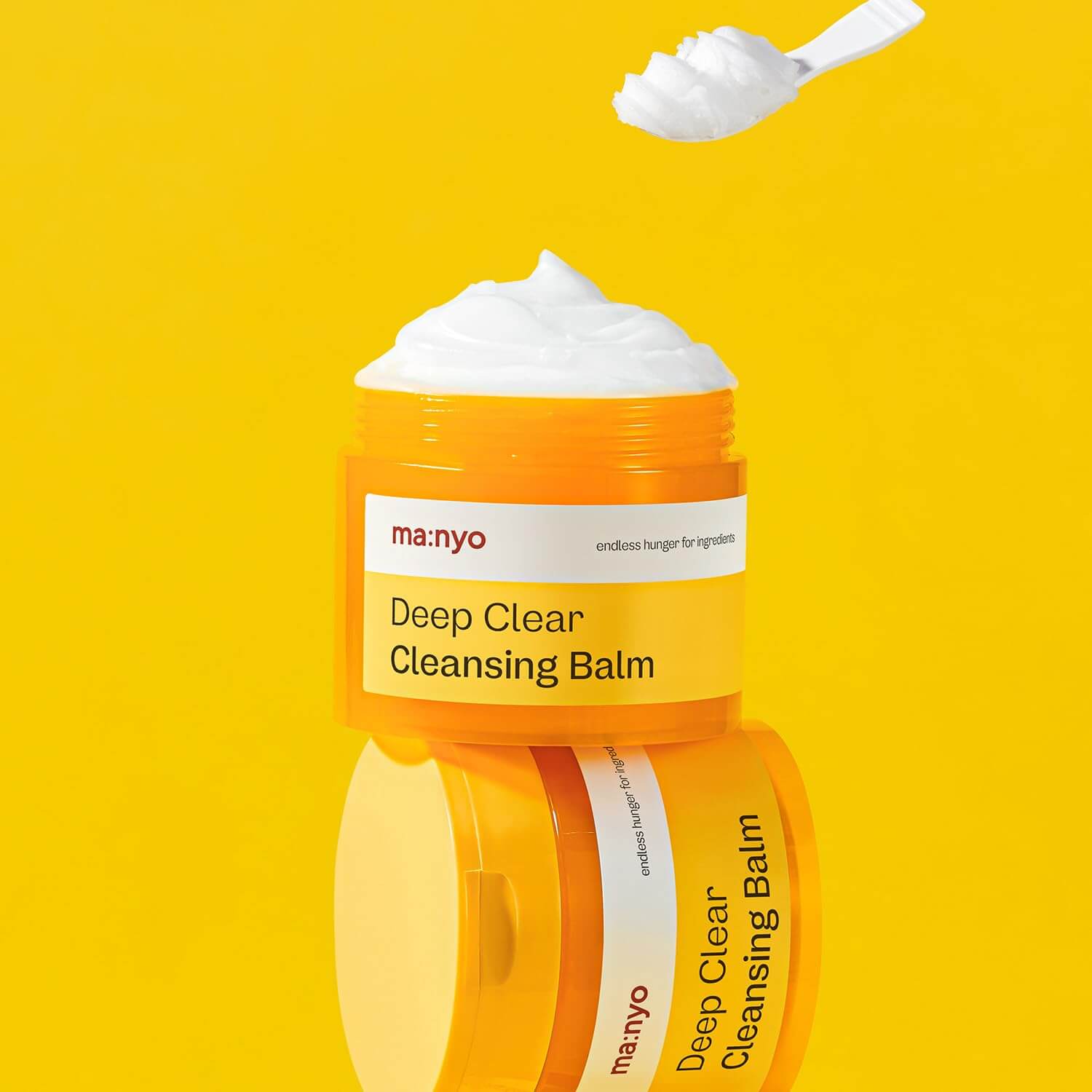 MANYO Deep Clear Cleansing Balm 132ml in vibrant yellow container with smooth balm texture, featured on a yellow background.