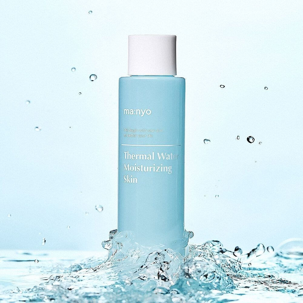 MANYO Thermal Water Moisturizing Skin 155ml bottle amidst splashing water, ideal for skincare hydration.