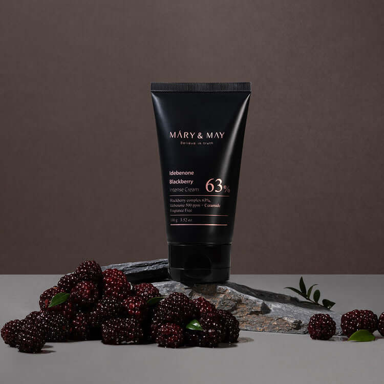 MARY & MAY Idebenone Blackberry Intense Cream surrounded by fresh blackberries on a stone surface.