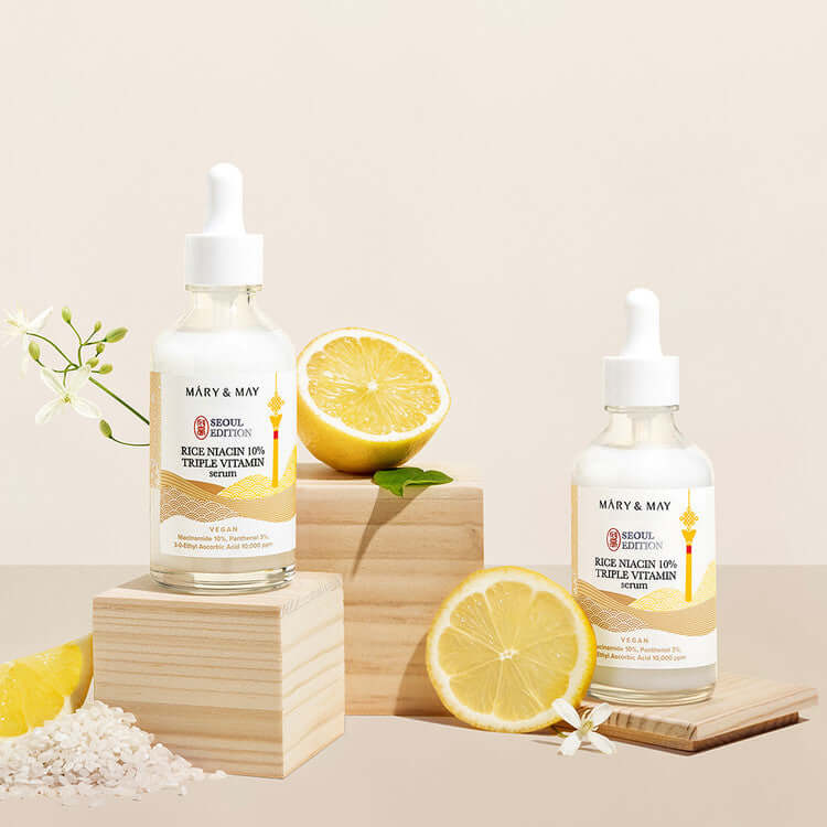 MARY & MAY Rice Niacin 10% triple Vitamin Serum bottles with lemons and rice for skincare.