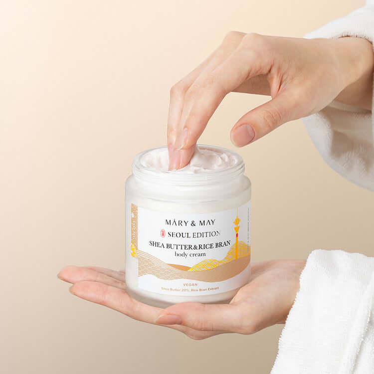 Hands holding MARY & MAY Shea Butter & Rice Bran body Cream jar