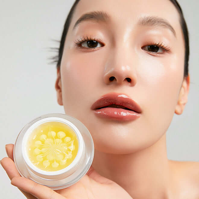 Woman holding MEDITHERAPY Melageran White Toning Cream 50ml with radiant skin and glossy lips.