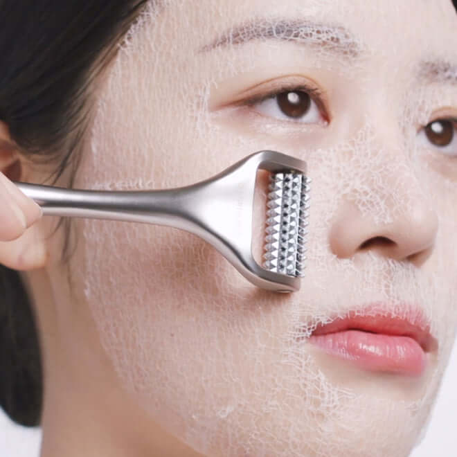 Woman applying MEDITHERAPY Wrinkle-Fit Mask with a skincare tool